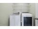 Modern laundry room with white washer and dryer, plus wire rack shelving at 226 Fair Oaks Ct, Mebane, NC 27302