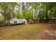 Fenced backyard featuring lush greenery and mature trees at 2415 Van Dyke Ave, Raleigh, NC 27607