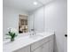 Bathroom featuring a white vanity with modern faucet, large mirror and a glimpse into the bedroom beyond at 2415 Van Dyke Ave, Raleigh, NC 27607