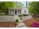 Charming cottage-style home featuring a welcoming front porch and a picket fence lined with colorful flowerbeds at 2415 Van Dyke Ave, Raleigh, NC 27607