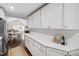 Bright kitchen featuring white cabinets, quartz countertops, and stainless steel appliances open to the dining and living areas at 2415 Van Dyke Ave, Raleigh, NC 27607