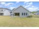 Large grassy backyard featuring a covered patio and view of a pond at 2434 Heron Watch Pl, Fuquay Varina, NC 27526