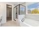 Bright bathroom with tiled floors, glass enclosed shower, and a soaking tub at 2434 Heron Watch Pl, Fuquay Varina, NC 27526