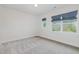 Bedroom featuring two windows with view of trees, neutral walls, and carpeted floors at 2434 Heron Watch Pl, Fuquay Varina, NC 27526