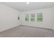 Carpeted bedroom featuring a large window with a woodsy backyard view at 2434 Heron Watch Pl, Fuquay Varina, NC 27526