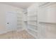 Large walk-in closet featuring custom shelving and carpeted floors at 2434 Heron Watch Pl, Fuquay Varina, NC 27526