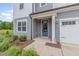 Close-up of home entrance featuring a stylish blue door and manicured landscaping at 2434 Heron Watch Pl, Fuquay Varina, NC 27526