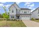 Charming two-story home with a well-manicured lawn and a two-car garage on a sunny day at 2434 Heron Watch Pl, Fuquay Varina, NC 27526