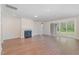 Open-concept living room with hardwood flooring, fireplace, and sliding glass doors providing ample natural light at 2434 Heron Watch Pl, Fuquay Varina, NC 27526