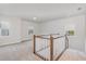 Upstairs loft area with neutral carpet, windows and staircase at 2434 Heron Watch Pl, Fuquay Varina, NC 27526