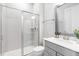 Bathroom featuring a glass-enclosed shower, modern fixtures, gray vanity, and white subway tile at 261 Emory Bluffs Dr, Holly Springs, NC 27540