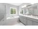 Modern bathroom with double vanity, white marble, and a window view of the trees at 261 Emory Bluffs Dr, Holly Springs, NC 27540