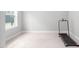 Bright bedroom with gray walls, a large window, and a black treadmill against the wall at 261 Emory Bluffs Dr, Holly Springs, NC 27540