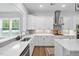 This kitchen features white cabinets, quartz countertops, stainless steel appliances, and hardwood floors at 261 Emory Bluffs Dr, Holly Springs, NC 27540
