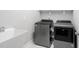 Efficient laundry room featuring modern washer and dryer units, along with a utility sink at 261 Emory Bluffs Dr, Holly Springs, NC 27540