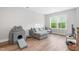 Cozy living room with a large sectional sofa, natural light, and a view of the trees outside at 261 Emory Bluffs Dr, Holly Springs, NC 27540