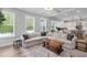 Open living room showcasing a large sectional sofa and seamless flow into the kitchen at 261 Emory Bluffs Dr, Holly Springs, NC 27540