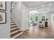 Staircase leading to a bright living room with coffered ceilings and large windows at 261 Emory Bluffs Dr, Holly Springs, NC 27540