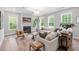 Cozy living room features a fireplace, a large sectional sofa, and views of the outdoors at 261 Emory Bluffs Dr, Holly Springs, NC 27540