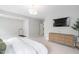 Large main bedroom featuring carpet, a large window, a dresser, and a private area for exercise equipment at 261 Emory Bluffs Dr, Holly Springs, NC 27540