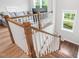 Bright staircase with white banisters and wooden handrail leading to the lower level at 261 Emory Bluffs Dr, Holly Springs, NC 27540