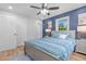 Comfortable bedroom with a blue accent wall, a ceiling fan, hardwood floors, and a double door closet at 2712 Cameron Dr, Sanford, NC 27332