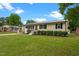 Charming single-story home with black shutters, an orange front door, manicured lawn, and metal roof at 2712 Cameron Dr, Sanford, NC 27332