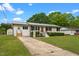 This single-story home boasts a well-kept lawn, updated metal roof, and charming orange front door at 2712 Cameron Dr, Sanford, NC 27332