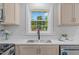 Kitchen sink with modern faucet, white countertops and bright natural light from window at 2712 Cameron Dr, Sanford, NC 27332