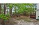 Spacious backyard featuring mature trees, lush greenery, and a wood deck at 286 Trillium Way, Clayton, NC 27527