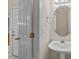 Bathroom featuring a pedestal sink, mirror, white door, and natural light at 286 Trillium Way, Clayton, NC 27527