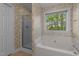 Inviting bathroom with white soaking tub, shower and a window overlooking trees at 286 Trillium Way, Clayton, NC 27527