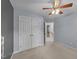 Bedroom with neutral carpet, light gray walls, ceiling fan, closet, and open door leading to another room at 286 Trillium Way, Clayton, NC 27527