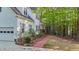 Well-maintained exterior featuring white siding, brick accents, a lush landscape, and a paved walkway at 286 Trillium Way, Clayton, NC 27527