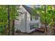 Angle view of the home's exterior featuring a deck, white siding, and lush greenery at 286 Trillium Way, Clayton, NC 27527