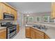 Well-lit kitchen featuring stainless steel appliances, a double sink, and wood cabinets at 286 Trillium Way, Clayton, NC 27527