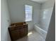 A bathroom with a window, bathtub, and vanity needing installation, offering a bright and functional space at 311 Chesapeake Commons St # 101, Garner, NC 27529
