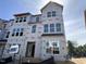 Unfinished new home exterior with visible framework, large windows, and modern architectural details in a residential area at 311 Chesapeake Commons St # 101, Garner, NC 27529