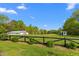 Expansive backyard with a lush green lawn, tall trees, and a classic black fence at 3542 Bason Rd, Mebane, NC 27302