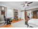 Spacious bedroom with hardwood floors, a ceiling fan, a large desk and bed, and an adjacent bathroom at 3542 Bason Rd, Mebane, NC 27302