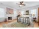 Bright bedroom featuring hardwood floors, a decorative fireplace, and large windows at 3542 Bason Rd, Mebane, NC 27302