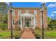 Charming brick home with a welcoming front porch, lampposts, and manicured landscaping at 3542 Bason Rd, Mebane, NC 27302