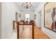 Upstairs hallway with hardwood floors, a decorative chandelier, and a seating area with two armchairs at 3542 Bason Rd, Mebane, NC 27302