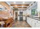 Open kitchen design with brick accent wall, white cabinetry, and wood beams at 3542 Bason Rd, Mebane, NC 27302