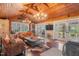 Cozy living room featuring wood paneled walls, hardwood floors, leather furniture, and a wood burning stove at 3542 Bason Rd, Mebane, NC 27302