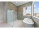Bathroom featuring a glass shower, soaking tub, decorative tile and bright window with exterior views at 3941 Wendell Blvd, Wendell, NC 27591