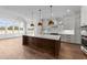 A modern kitchen with stainless steel appliances, an island, and decorative pendant lighting at 3941 Wendell Blvd, Wendell, NC 27591
