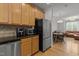 Kitchen shows stainless steel appliances and wood cabinets open to an adjacent dining and living space at 400 W Rosemary St # 104, Chapel Hill, NC 27516