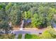 An aerial shot reveals a charming blue house nestled amongst a sea of mature trees in a serene neighborhood at 403 Mayodan Dr, Cary, NC 27511