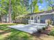 A gray home with a large deck in the backyard, surrounded by lush greenery and landscaping at 403 Mayodan Dr, Cary, NC 27511